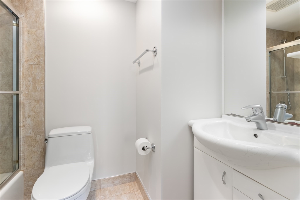 85 Brainerd Road, Unit 507 Boston, MA 02134 - Photo 16 of 23 a bathroom with a toilet a sink and mirror
