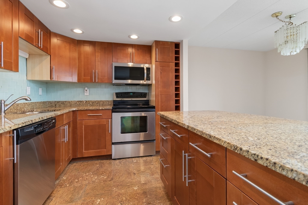 85 Brainerd Road, Unit 507 Boston, MA 02134 - Photo 6 of 23 a kitchen with stainless steel appliances granite countertop a stove a sink and a microwave