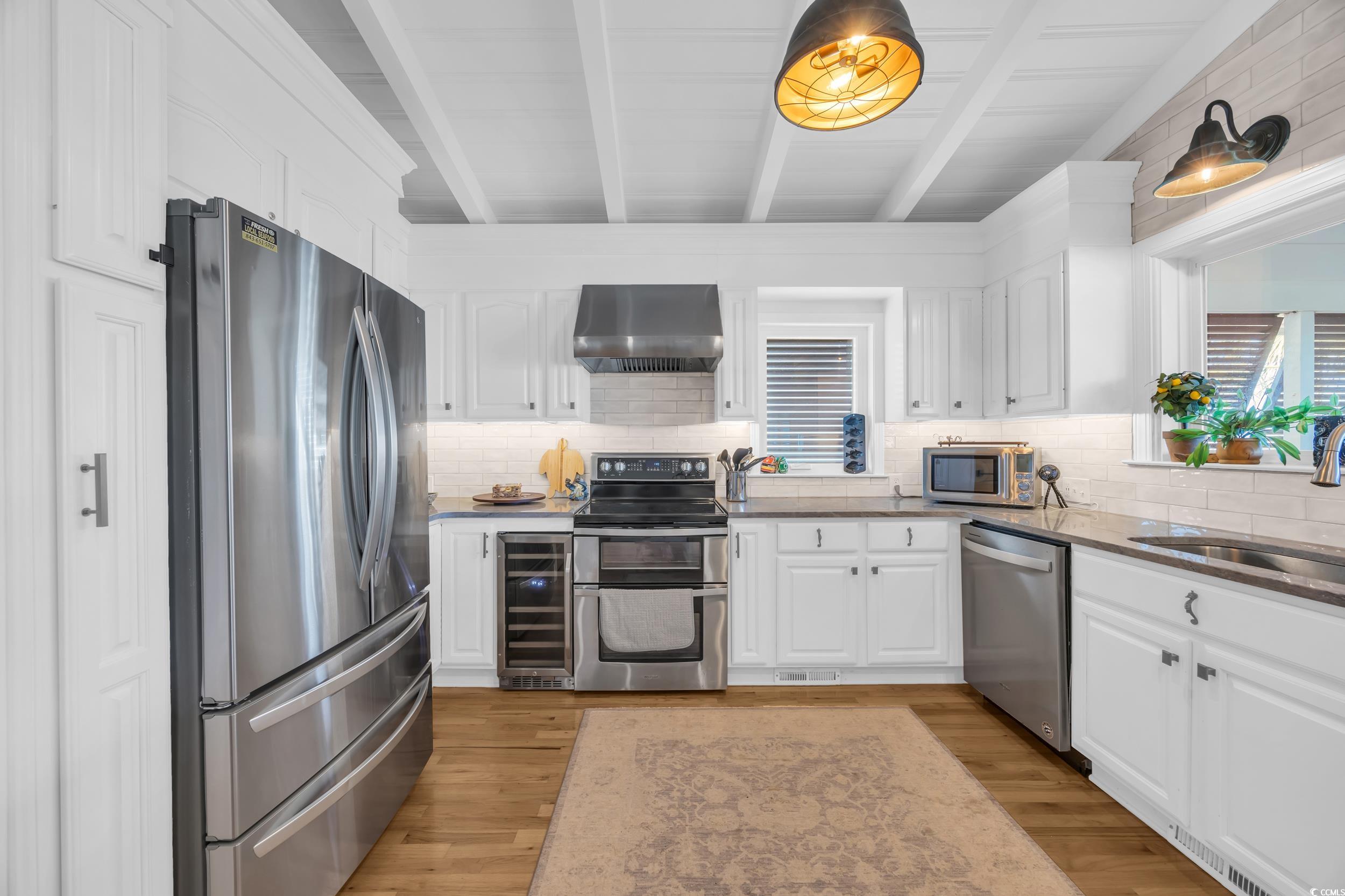 1332 South Waccamaw Drive Murrells Inlet, SC 29576 - Photo 31 of 39 Kitchen featuring white cabinetry, appliances with stainless steel finishes, beverage cooler, tasteful backsplash, and beamed ceiling