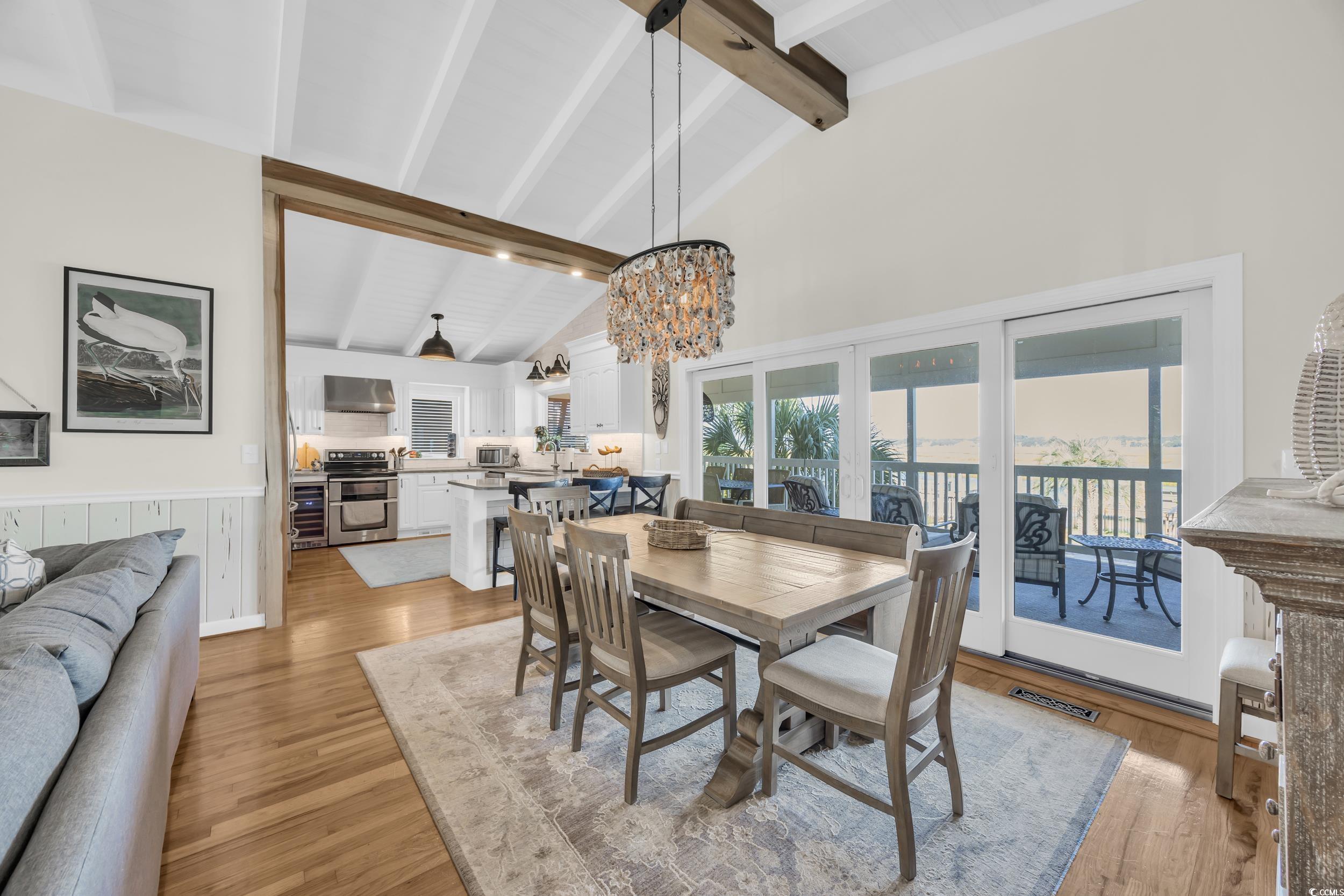 1332 South Waccamaw Drive Murrells Inlet, SC 29576 - Photo 32 of 39 Dining area with light wood finished floors, high vaulted ceiling, beamed ceiling, a chandelier, and a wainscoted wall