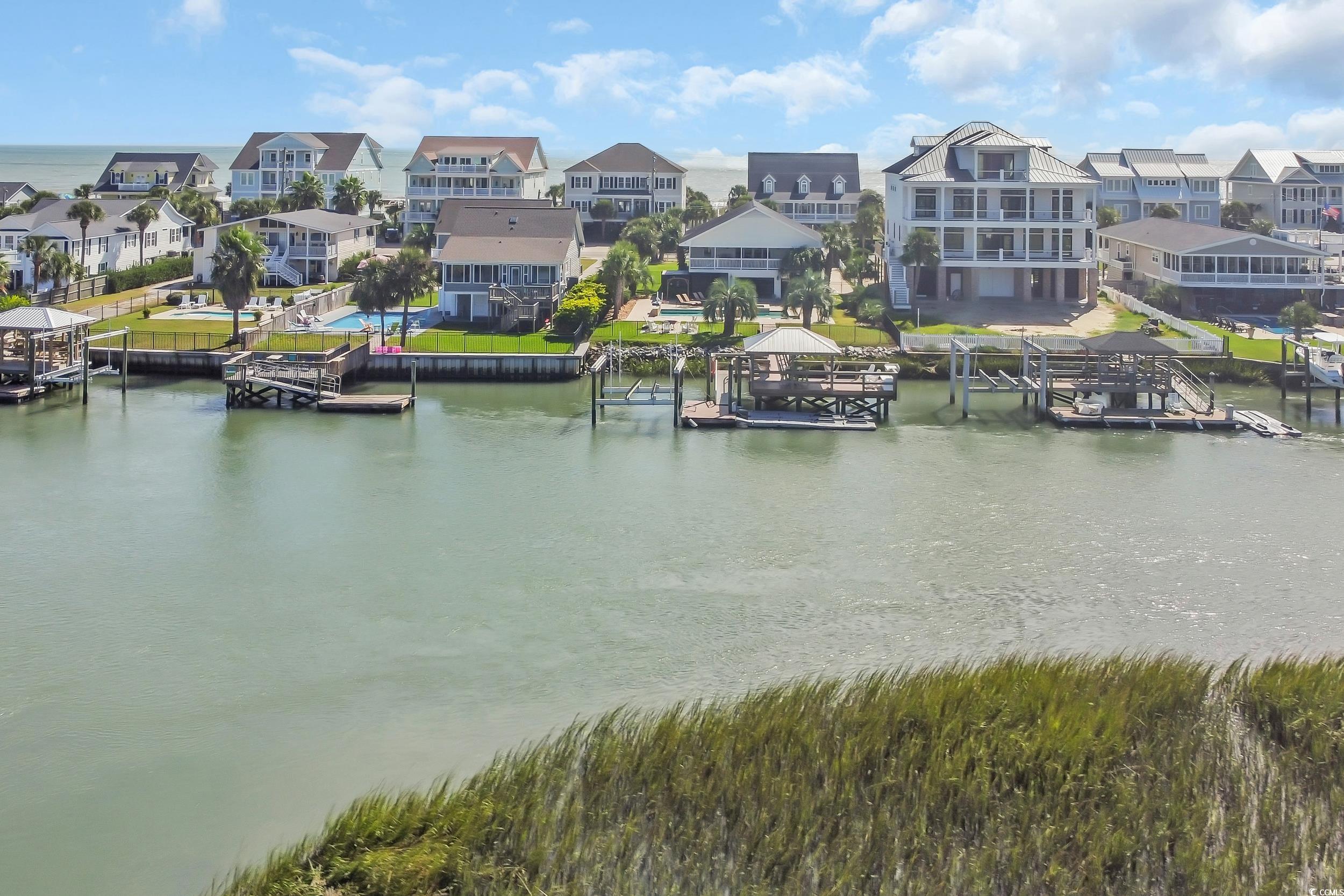 1332 South Waccamaw Drive Murrells Inlet, SC 29576 - Photo 5 of 39 Water view featuring a dock, boat lift, and nearby suburban area