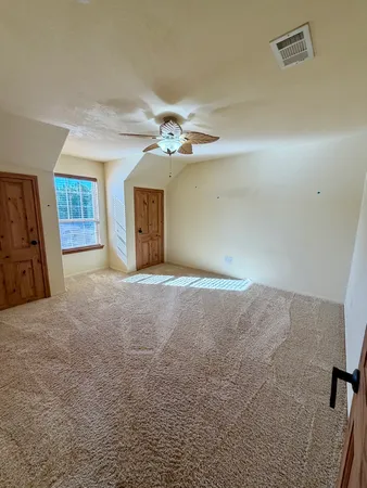 a view of a livingroom with a ceiling fan and window