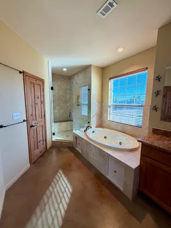 a spacious bathroom with a tub sink and mirror