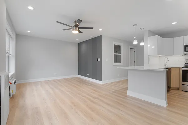 wooden floor in an empty room with a kitchen