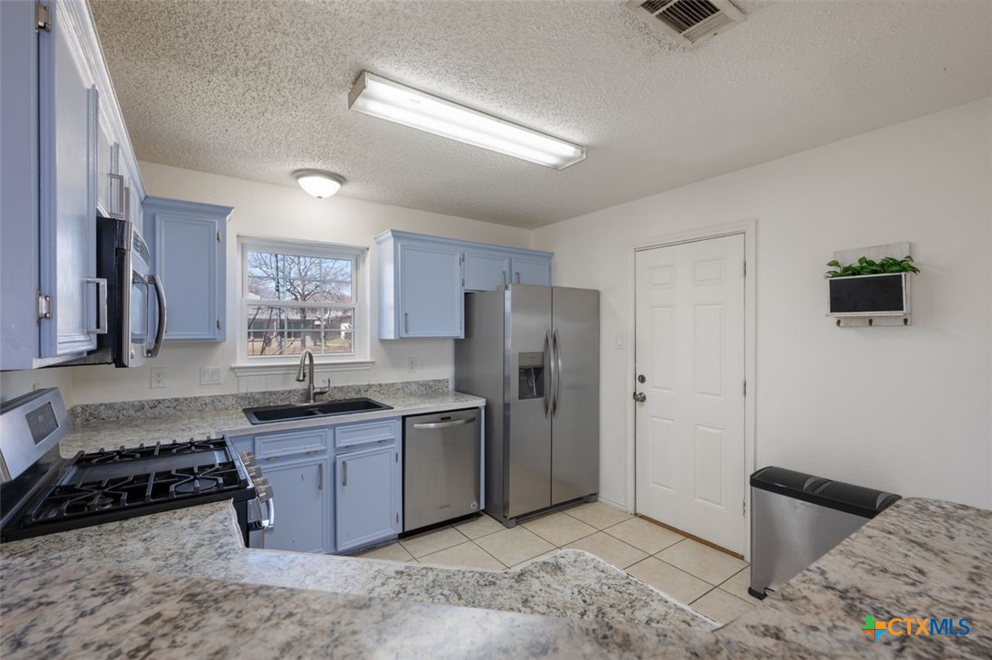 2307 Bernice Circle Copperas Cove, TX 76522 - Photo 13 of 32 a kitchen with stainless steel appliances granite countertop a sink stove and refrigerator