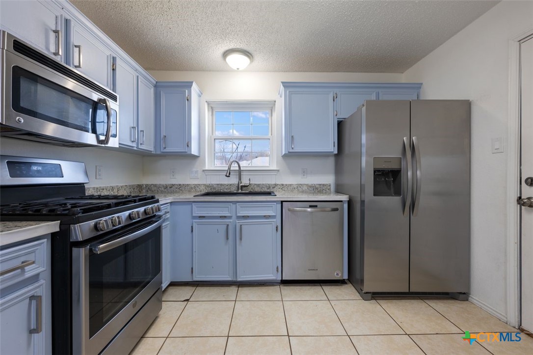 2307 Bernice Circle Copperas Cove, TX 76522 - Photo 14 of 32 a kitchen with stainless steel appliances granite countertop a stove a refrigerator and a microwave