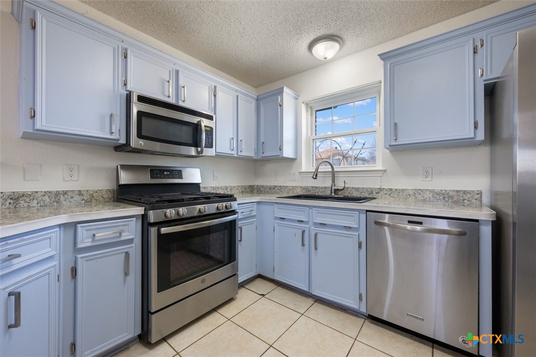 2307 Bernice Circle Copperas Cove, TX 76522 - Photo 15 of 32 a kitchen with stainless steel appliances granite countertop a sink dishwasher a stove and a microwave oven with cabinets