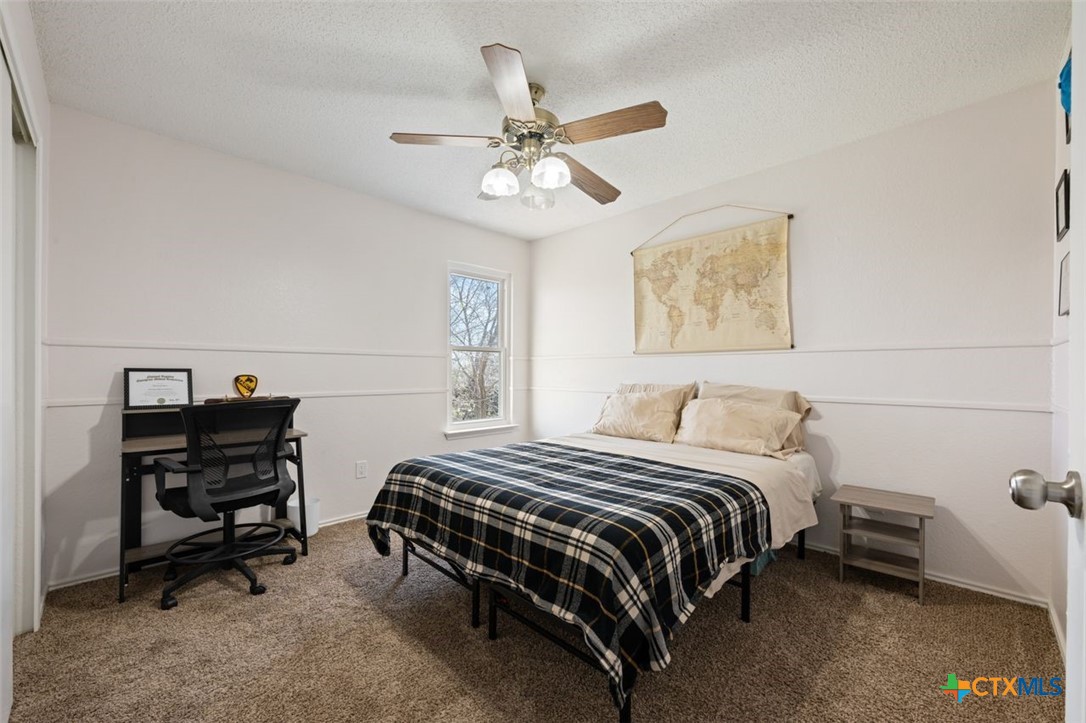 2307 Bernice Circle Copperas Cove, TX 76522 - Photo 25 of 32 a bedroom with a bed and a chandelier