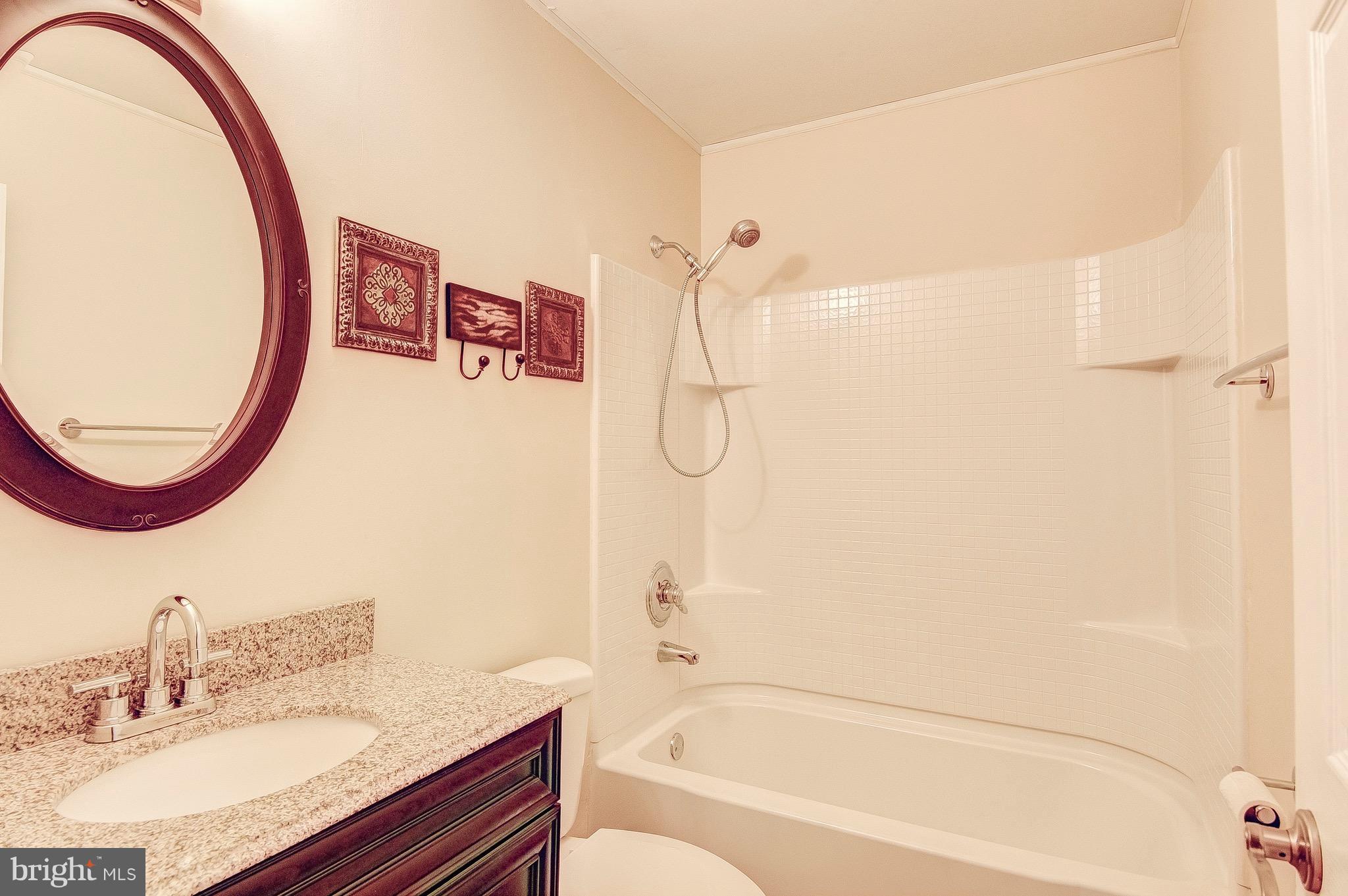 2616 Apple Way Dunkirk, MD 20754 - Photo 15 of 29 a bathroom with a granite countertop sink mirror toilet and bathtub
