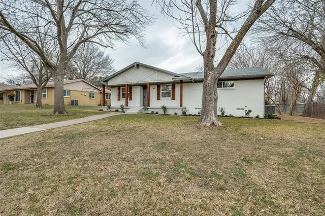 a white house that has a tree in front of it