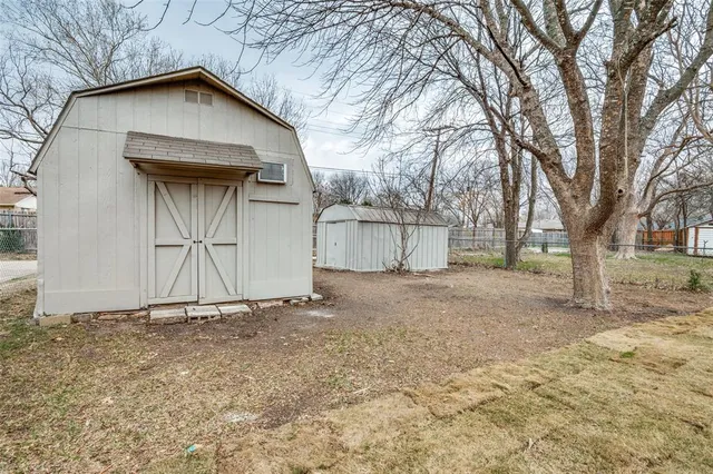 a backyard of a house with large trees and brick wall