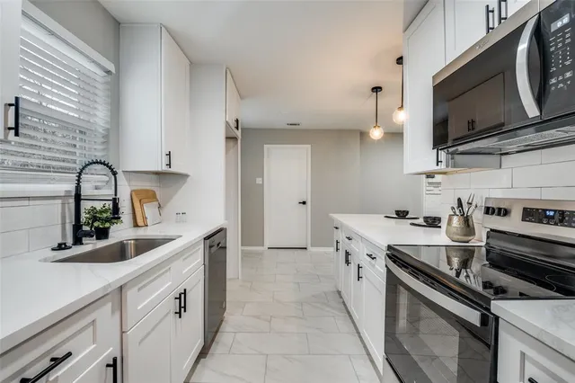 a kitchen with stainless steel appliances granite countertop a sink stove and microwave