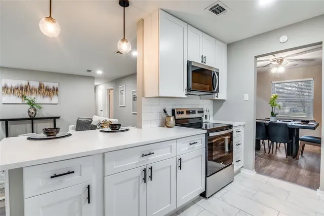 a kitchen with a sink a stove and chairs