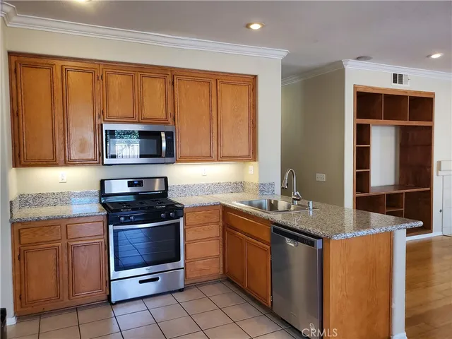 a kitchen with stainless steel appliances granite countertop a sink stove and microwave