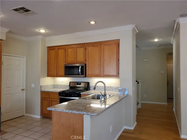 a kitchen with granite countertop a sink stainless steel appliances and cabinets