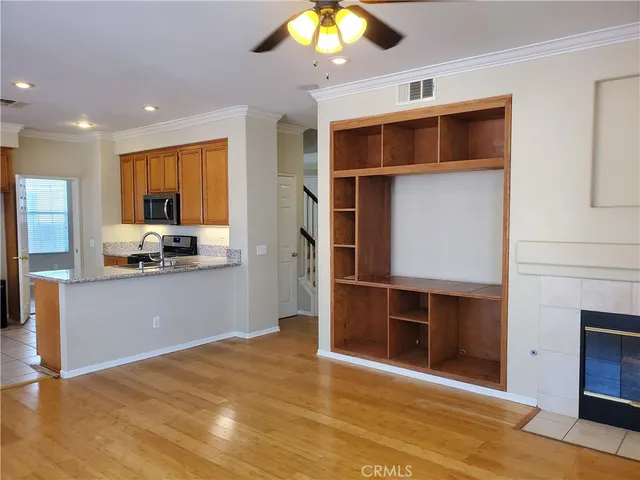 a view of a kitchen with kitchen island a sink wooden floor and a refrigerator