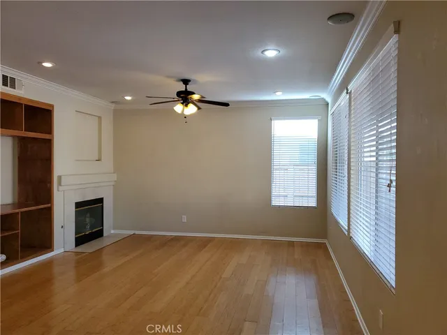 an empty room with windows and fireplace