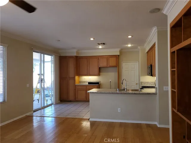 a kitchen with kitchen island granite countertop a sink cabinets and stainless steel appliances