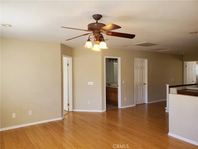 a view of a room with a ceiling fan and wooden floor
