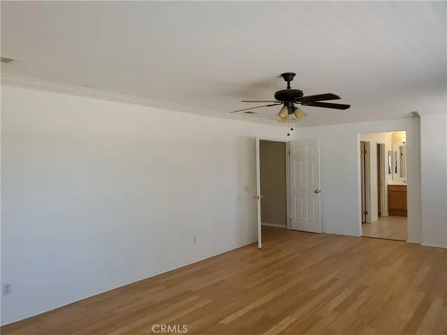 a view of a room with wooden floor and ceiling fan