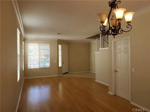 a view of a room with wooden floor and chandelier