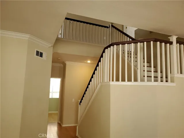 a view of staircase with railing and a window