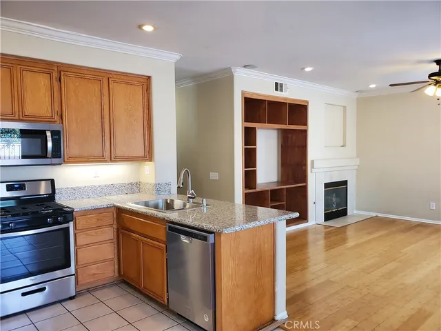 a kitchen with stainless steel appliances granite countertop a stove a sink and a microwave