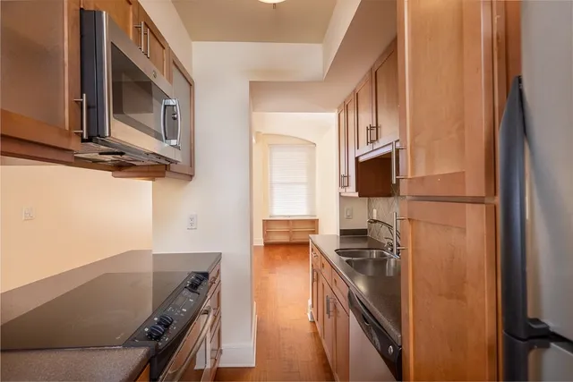 a kitchen with stainless steel appliances granite countertop a stove a sink and a refrigerator
