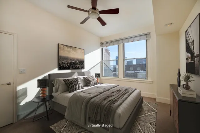 a bedroom with a bed a window and a chandelier