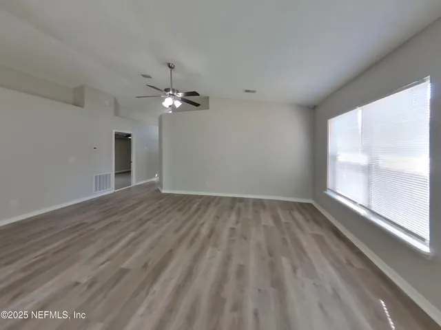 wooden floor in an empty room with a window