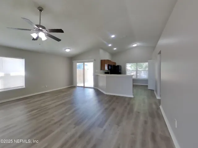 a view of empty room with wooden floor