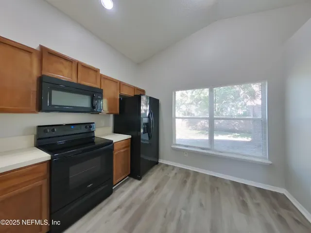 a kitchen with a stove a microwave and a window
