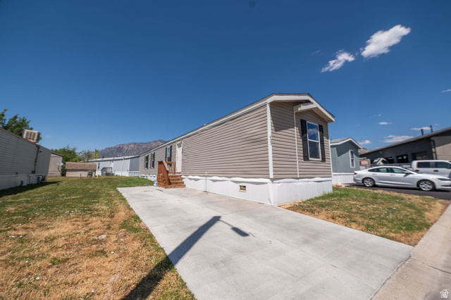 2491 Highway 89, Unit 403 Pleasant View, UT 84404 - Photo 28 of 32 Manufactured home with light brown horizontal siding, a white foundation, and a dark brown wooden entry staircase