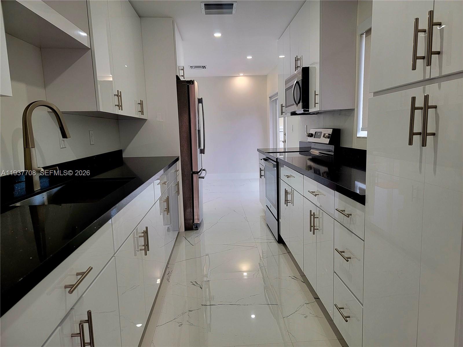 a kitchen with stainless steel appliances granite countertop a stove a sink and a refrigerator