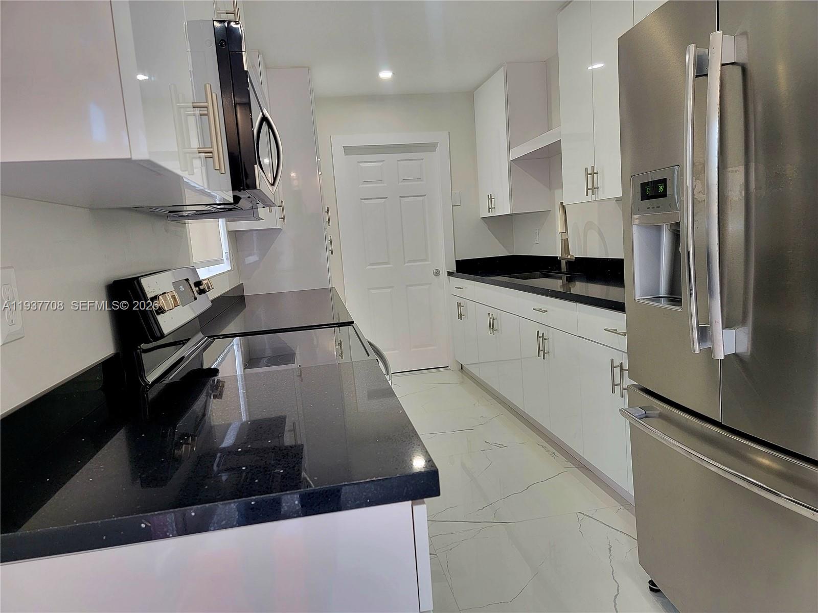 14860 Southwest 307th Street Homestead, FL 33033 - Photo 14 of 14 a kitchen with stainless steel appliances granite countertop a sink a stove and a refrigerator