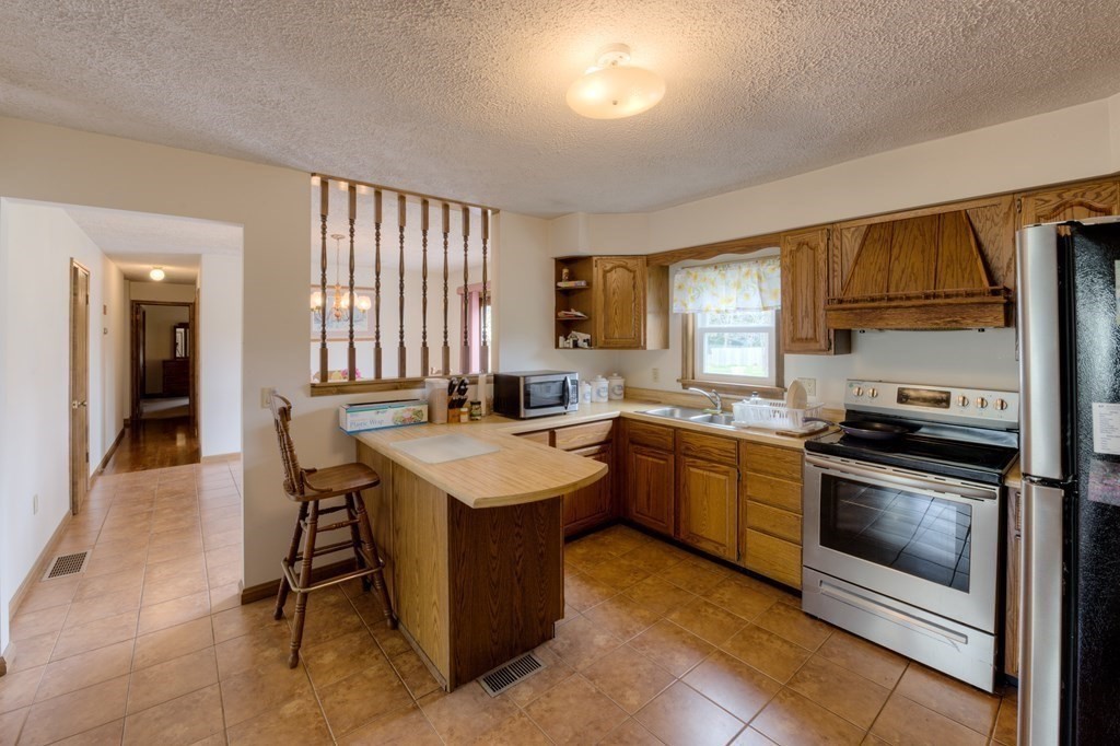 23 Riverside Street Three Rivers, MA 01080 - Photo 3 of 33 a kitchen with a sink stove and refrigerator