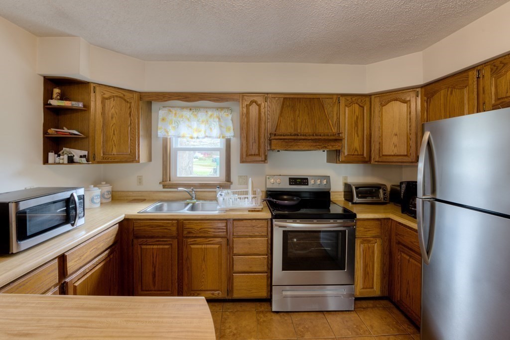 23 Riverside Street Three Rivers, MA 01080 - Photo 5 of 33 a kitchen with a sink stove and refrigerator