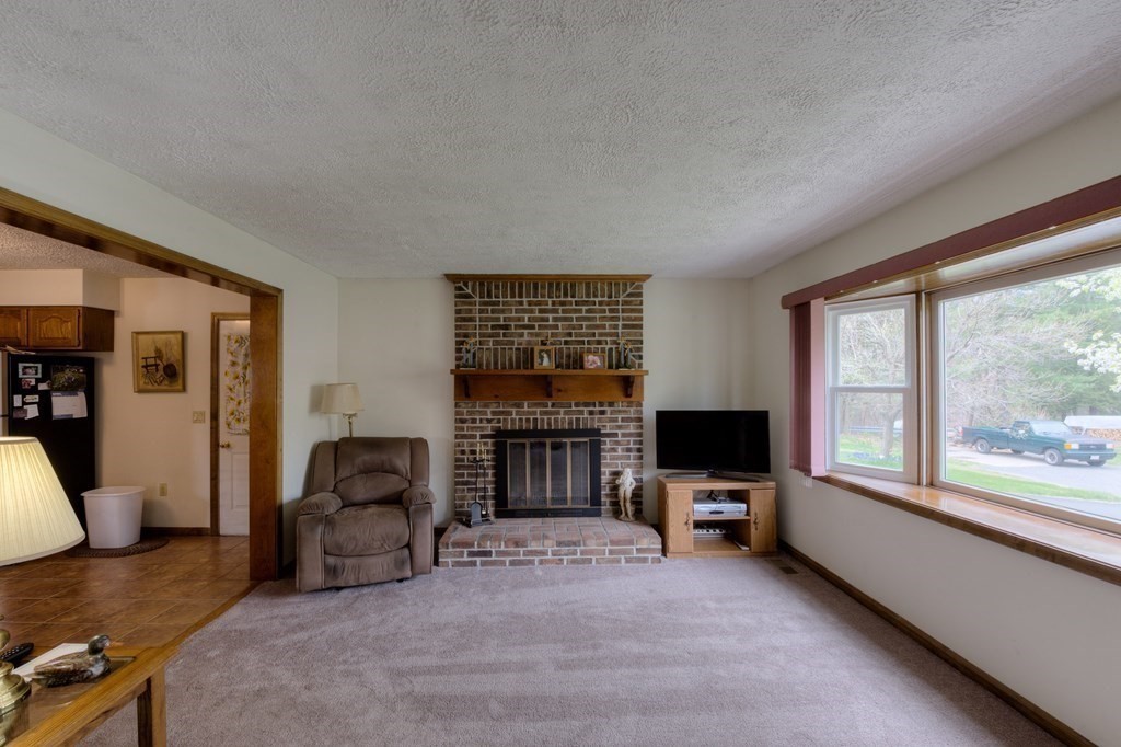23 Riverside Street Three Rivers, MA 01080 - Photo 10 of 33 a living room with furniture flat screen tv and a fireplace