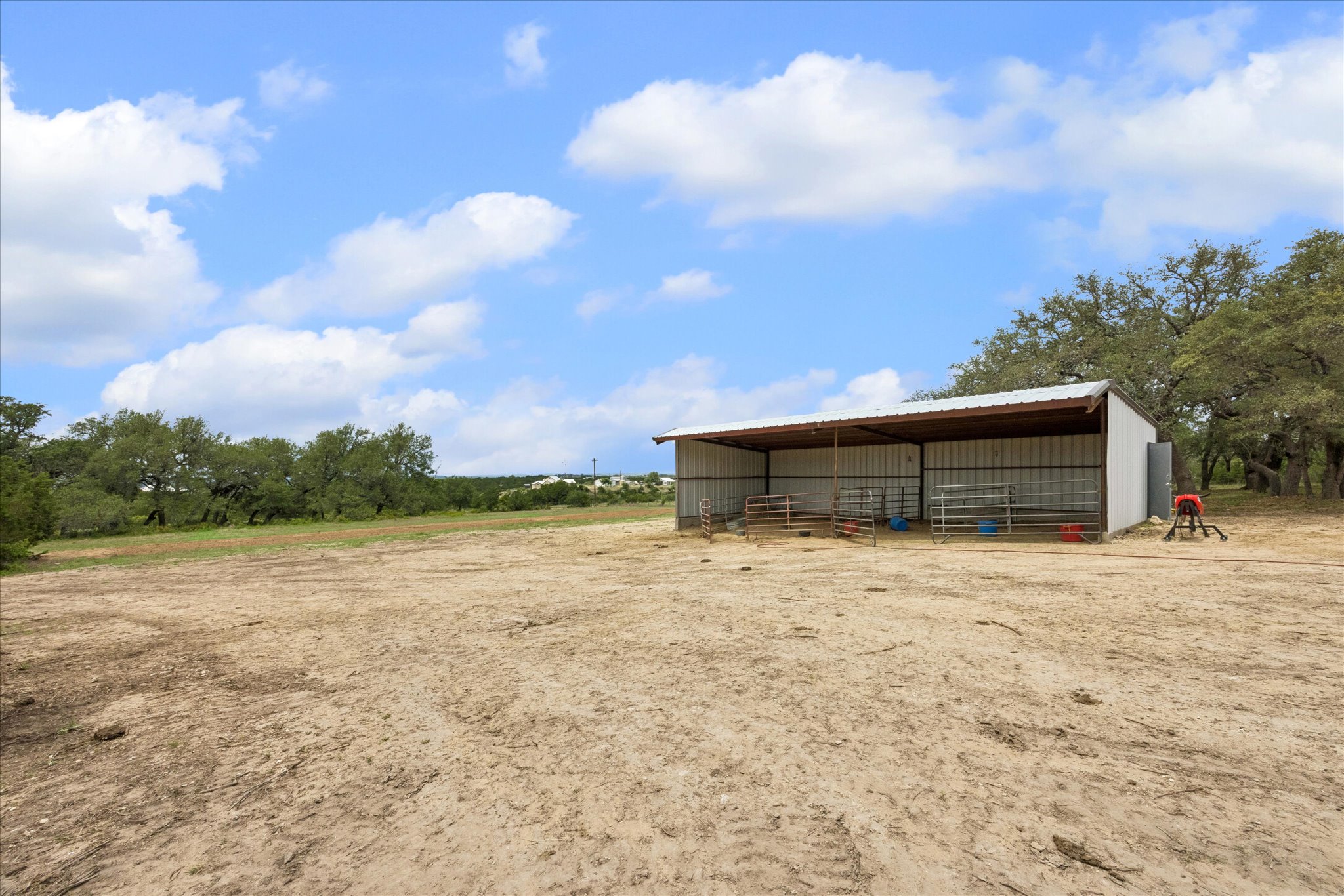 6411 West Fitzhugh Road Dripping Springs, TX 78620 - Photo 27 of 34 Expansive open acreage featuring a metal pole barn with an attached shed roof