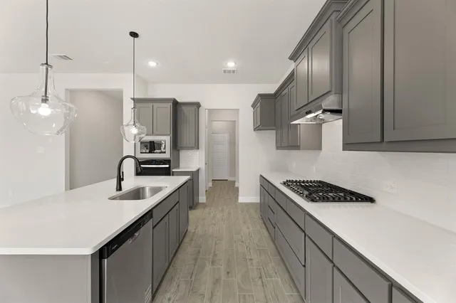 a kitchen with stainless steel appliances a sink stove and cabinets