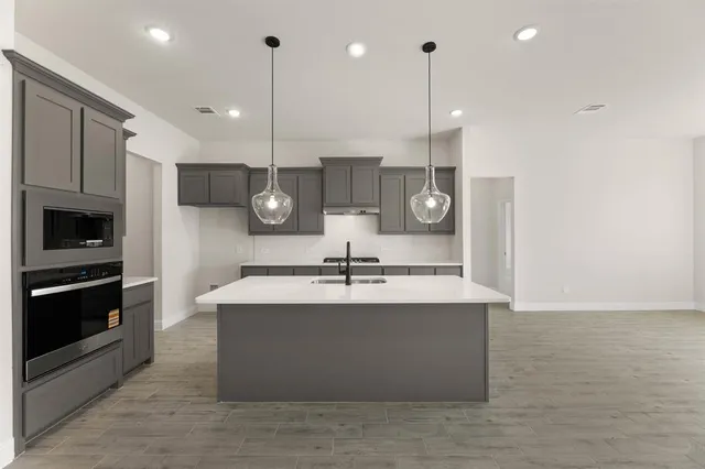 a large kitchen with kitchen island a sink stainless steel appliances and cabinets