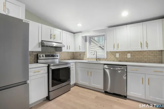 a kitchen with granite countertop white cabinets and white appliances