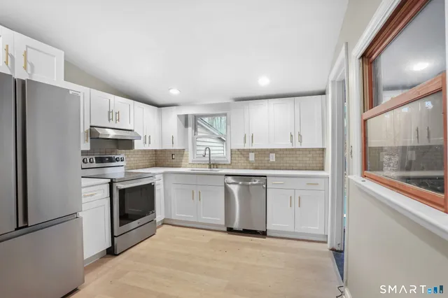 a kitchen with granite countertop cabinets stainless steel appliances and a sink