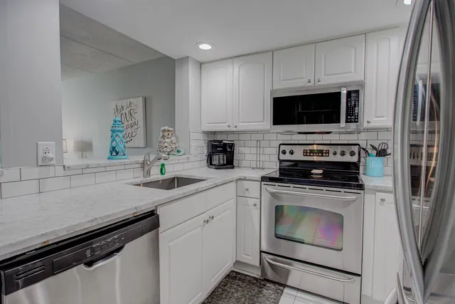 a kitchen with white cabinets and stainless steel appliances