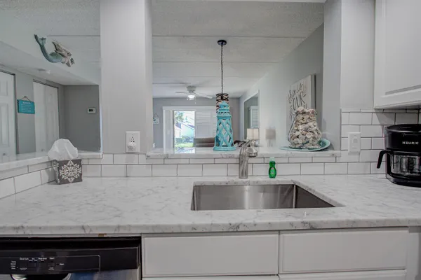 a kitchen with stainless steel appliances granite countertop a sink and a refrigerator