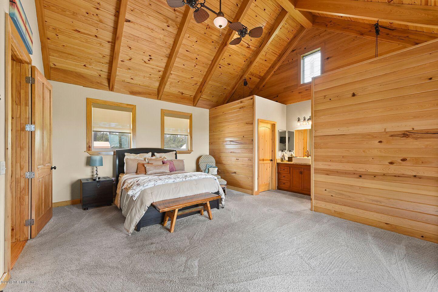 12715 Sawpit Road Jacksonville, FL 32226 - Photo 11 of 35 a spacious bedroom with a bed and a chandelier