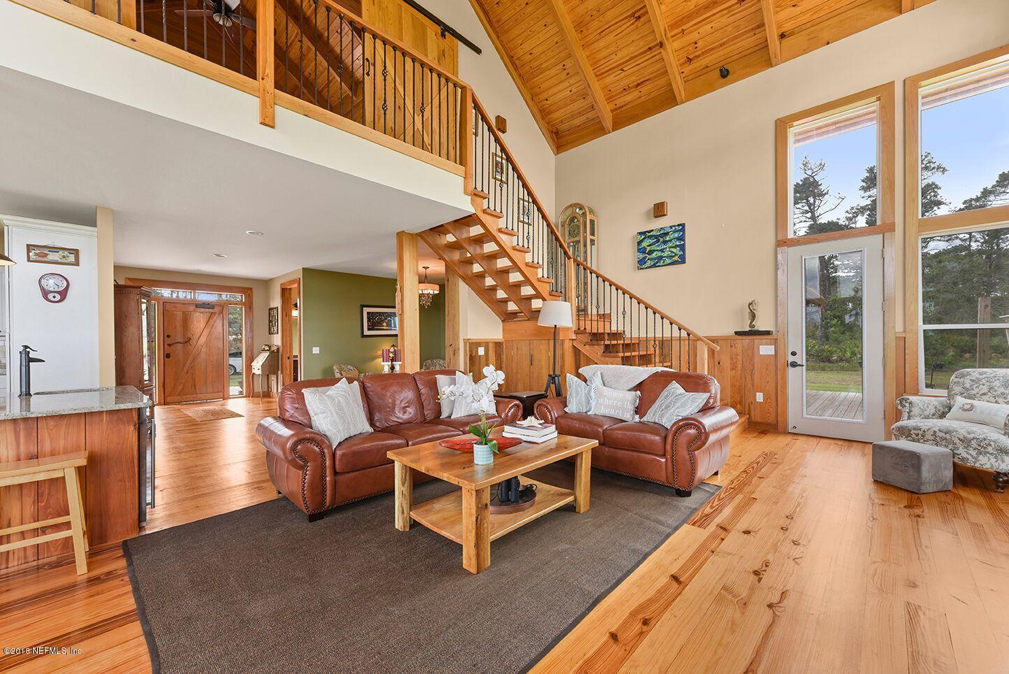 12715 Sawpit Road Jacksonville, FL 32226 - Photo 14 of 35 a living room with furniture floor to ceiling windows and wooden floor