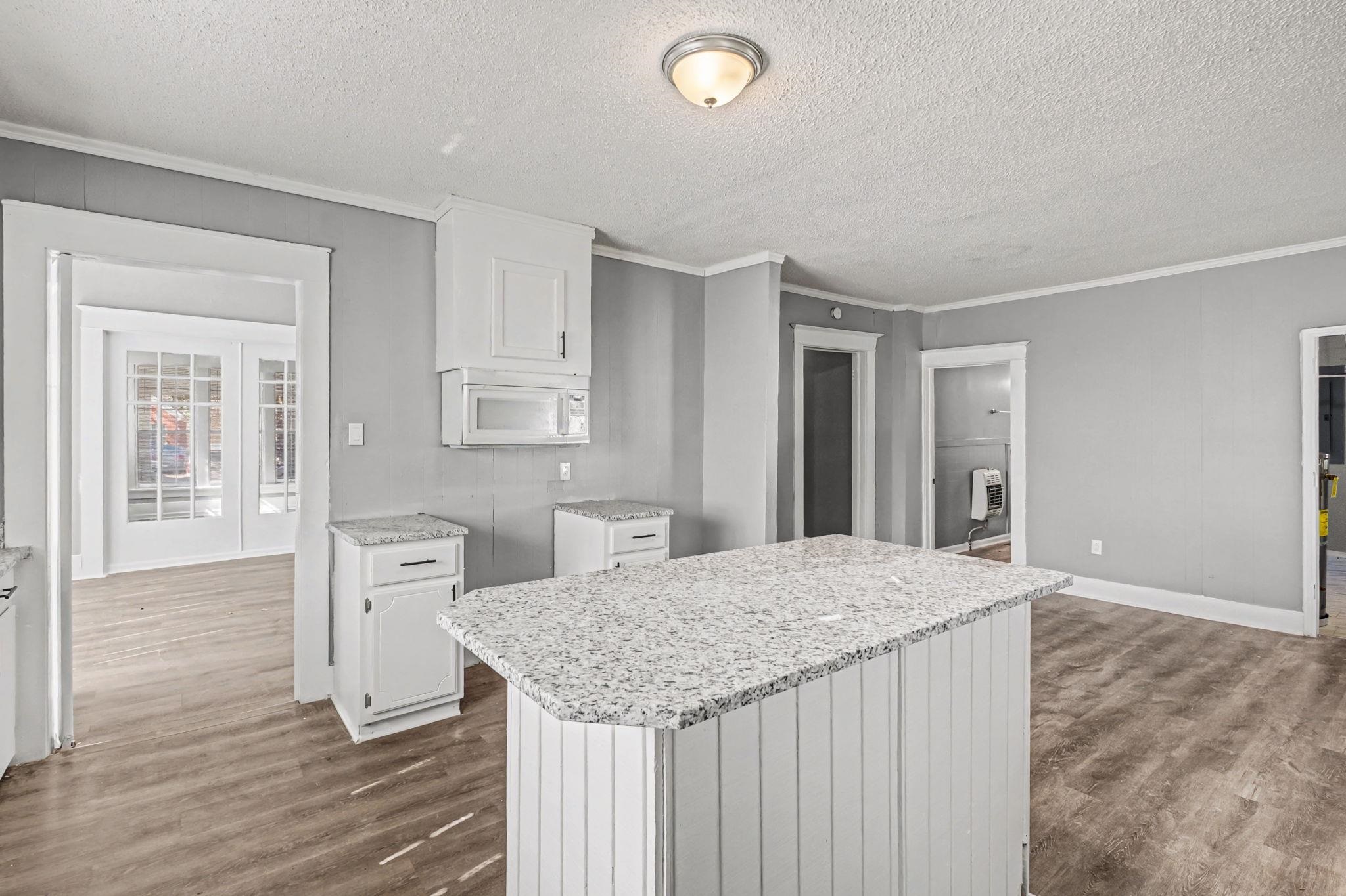 320 North High Street Covington, TN 38019 - Photo 12 of 32 a living room with stainless steel appliances kitchen island granite countertop wooden floor and cabinets