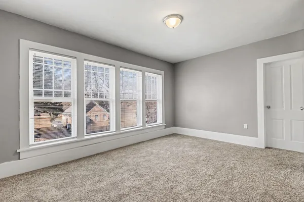 a kitchen with granite countertop white cabinets and a window