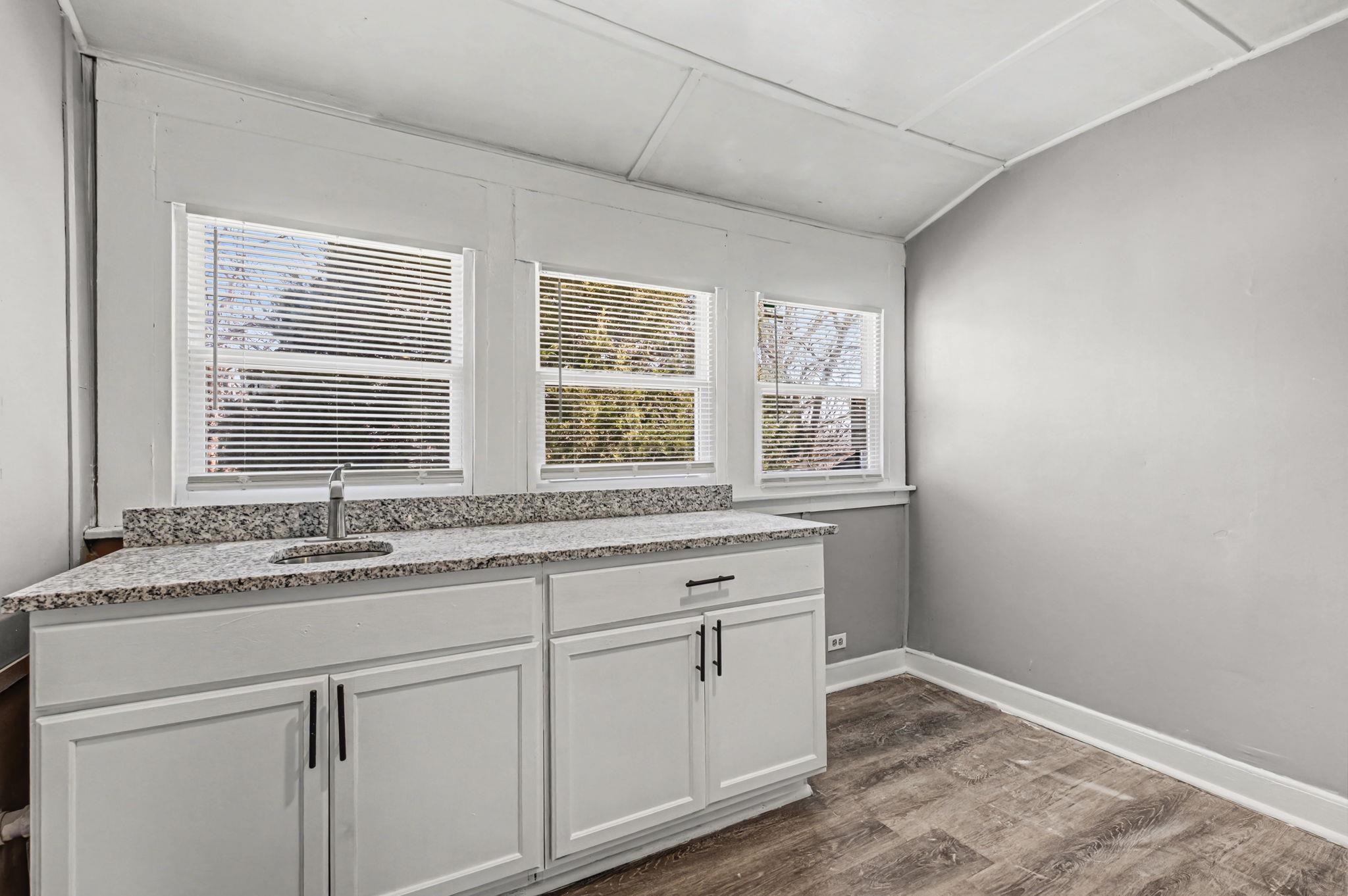 320 North High Street Covington, TN 38019 - Photo 16 of 32 a kitchen with granite countertop white cabinets and a window